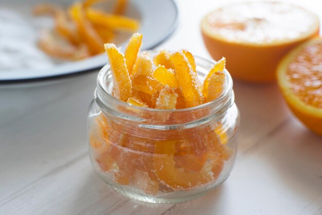 Candied orange sticks in sugar served in a glass.