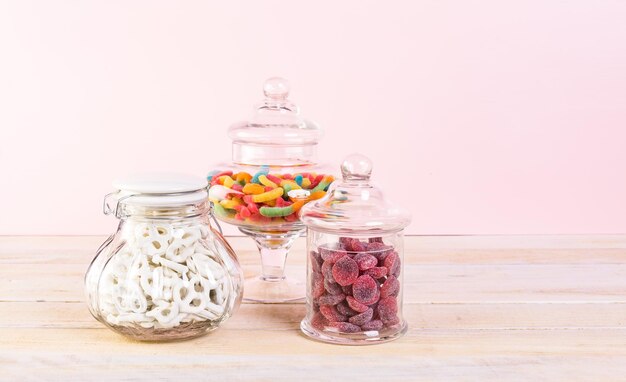 Candies in candy jar on wood table.