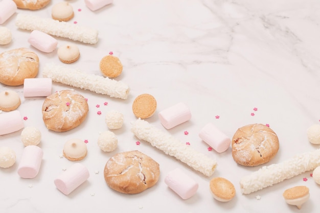 Candies and cookies on white marble background