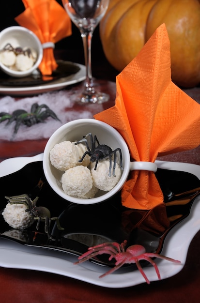 Candies in the form of spider eggs in a cup on the table in Halloween