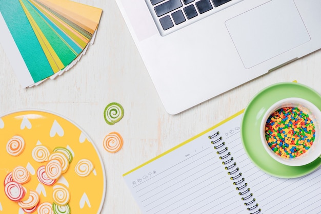 Candies, headphones and notepad on wooden table. Open space for copy.