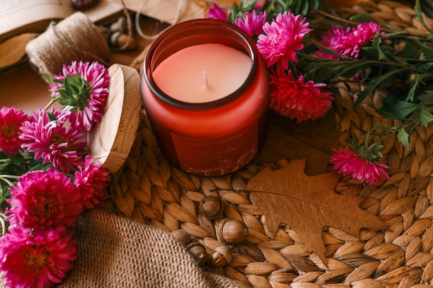 candle and aster flowers in autumn interior