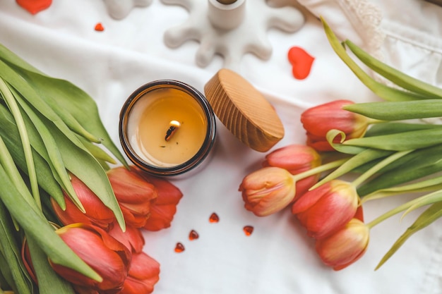 Photo candle and bouquet of red tulips spring aesthetics