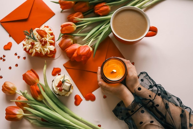 Candle and bouquet of red tulips spring aesthetics