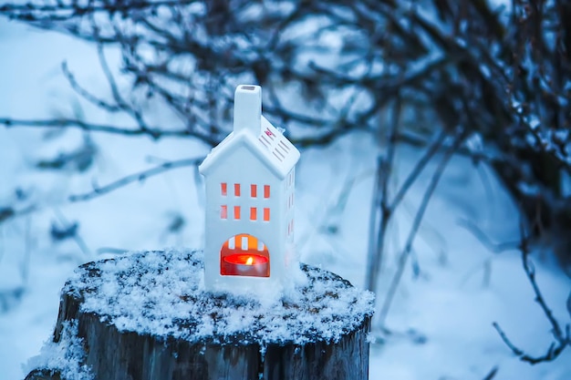 Candle burning in the white lantern in the winter garden