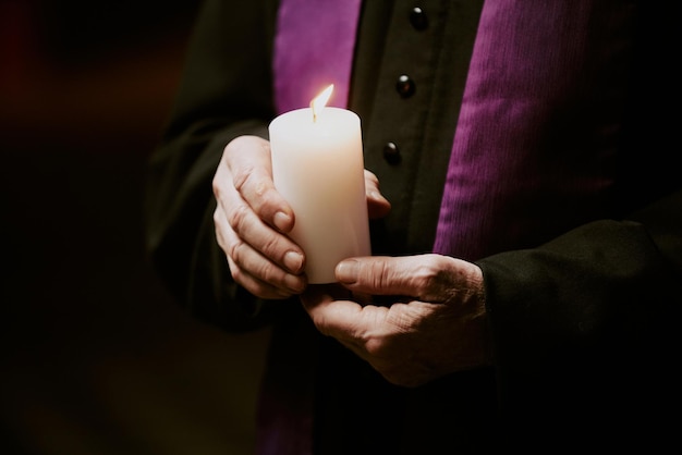candle in catholic priests hands