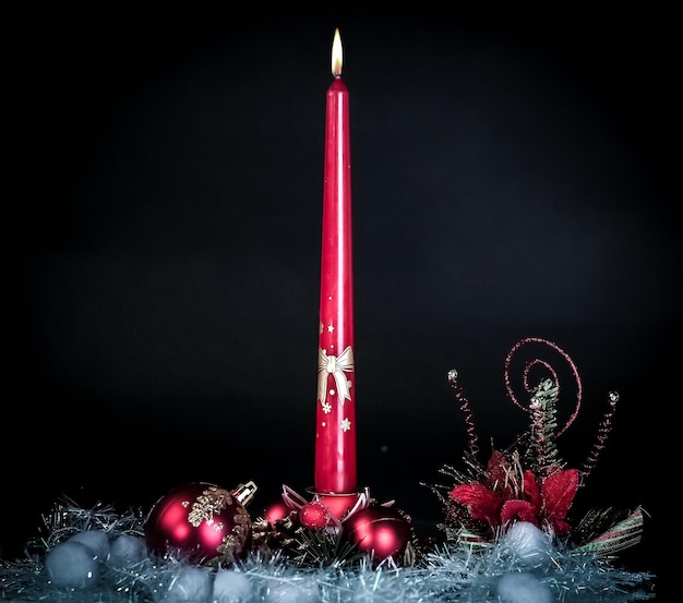 Candle and christmas composition on a black background