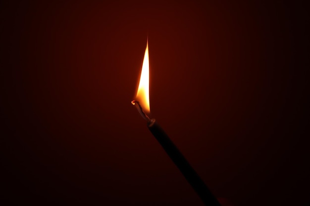 A candle in the dark, a flame of fire lit.