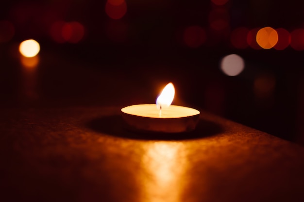 Candle in the dark with bokeh background.