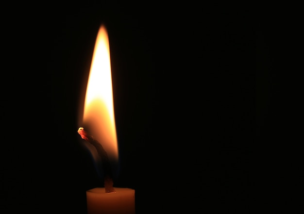 Candle flame burning on black background.