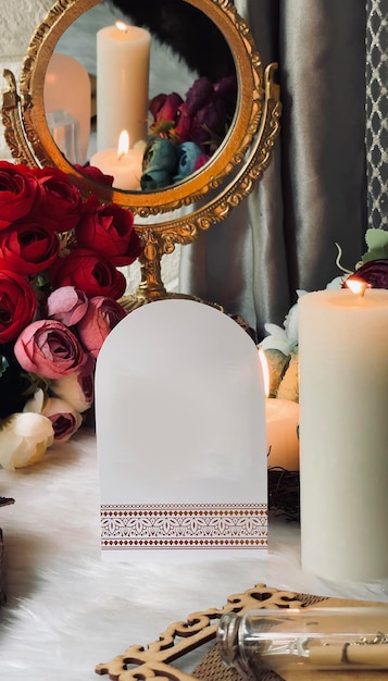 A candle holder with a red rose in the background and a mirror with a red rose in the background.