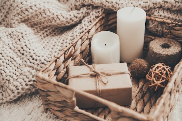 Candle and knitting clothes in wicker basket