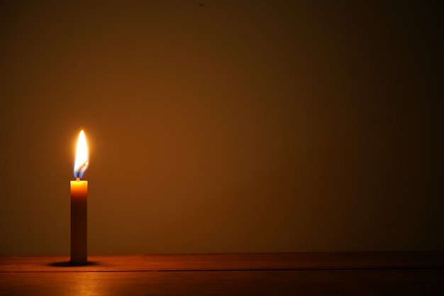 Photo candle light in darkness with empty space for your work