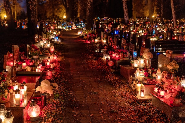 Candle lights on graves and tombstones in cemetery at night on
all souls day