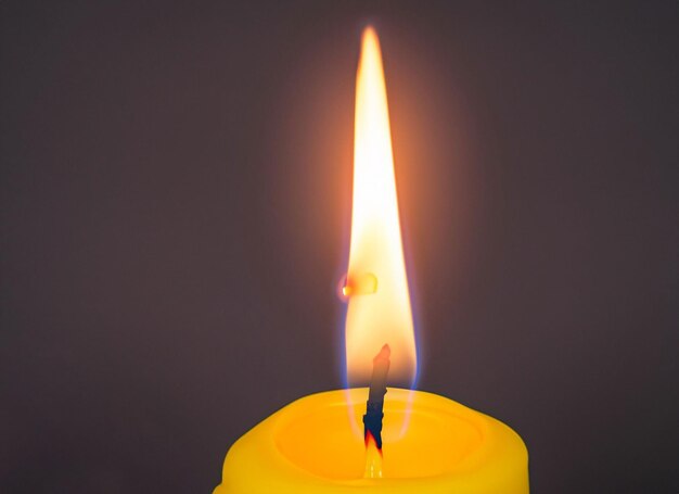 Foto una candela accesa a fiamma sullo sfondo nero