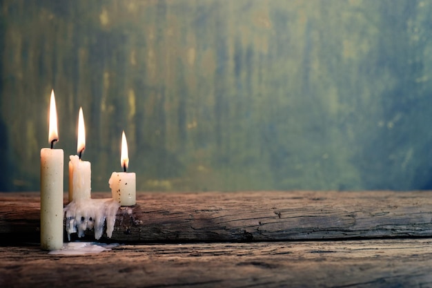 Candle on a old oak wooden table Beautiful gold backgroundReligion concept