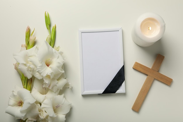 Candle photo frame flowers and cross on white background top view