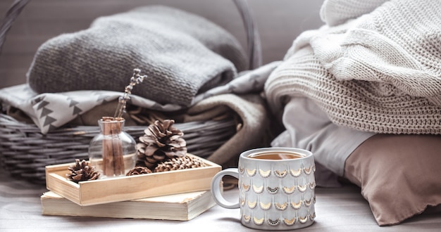 Photo candle, pine cones on wooden tray and blankets