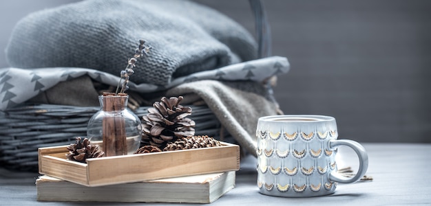 Photo candle, pine cones on wooden tray and blankets