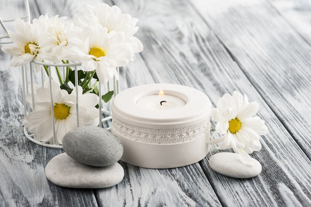 Candle and stones on wooden background