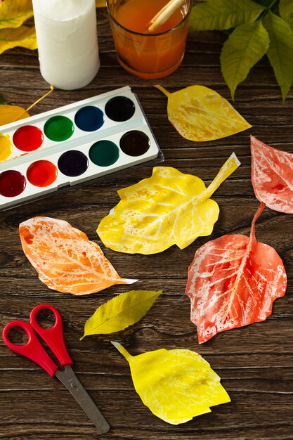 Candle and watercolor paint to create autumn leaves Childrens art project