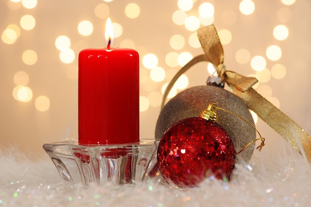 Candle with baubles on blurred background