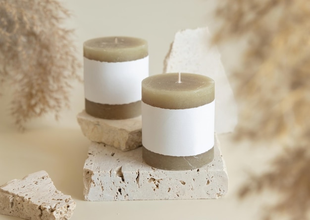 Photo candle with label on beige stone near dried pampas grass close up copy space mock up