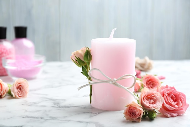 Candle with roses on marble table Space for text