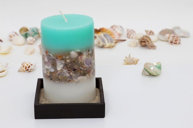 A candle with a sea shell on it