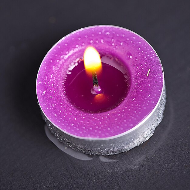 candle with water drops on black stone