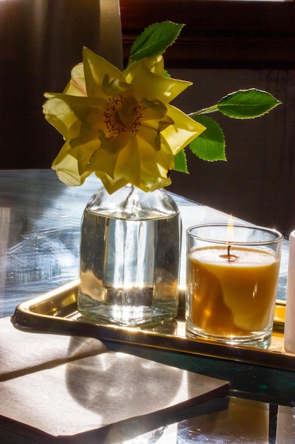 Photo a candle and a yellow flower are on a tray with a candle.