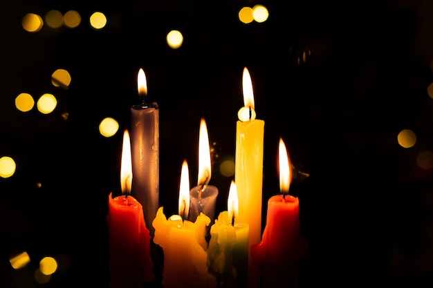 Candlelight Day. Traditional Colombian holiday. Group of colored candles lit at night with unfocused lights in the background. Copy space.