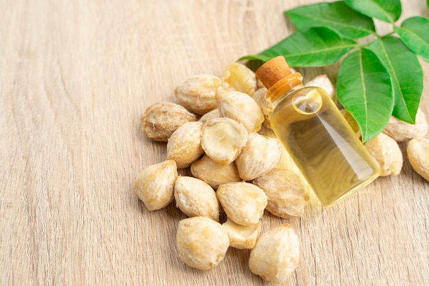 candlenut essential oil on wooden natural background