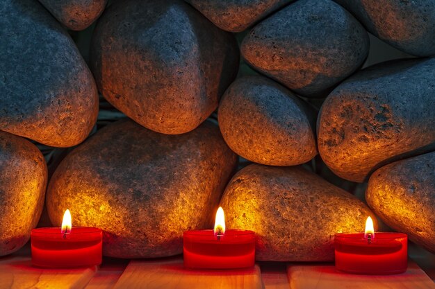 Candles are lit on the background of the sauna stones. Preparing for the ceremony bathhouse