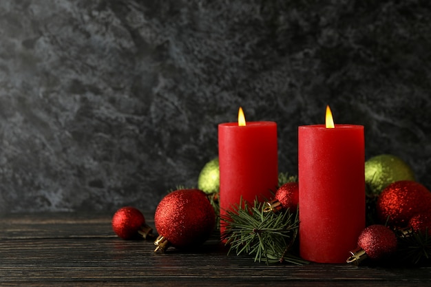 Candles, baubles and pine branches on wooden background