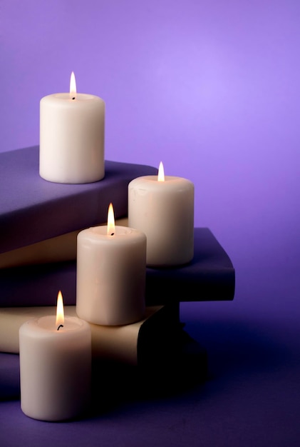 candles and books with purple background