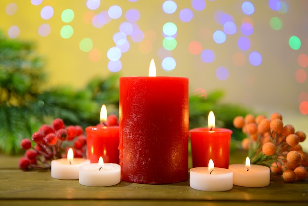 Свечи и рождественские украшения на ярком фоне