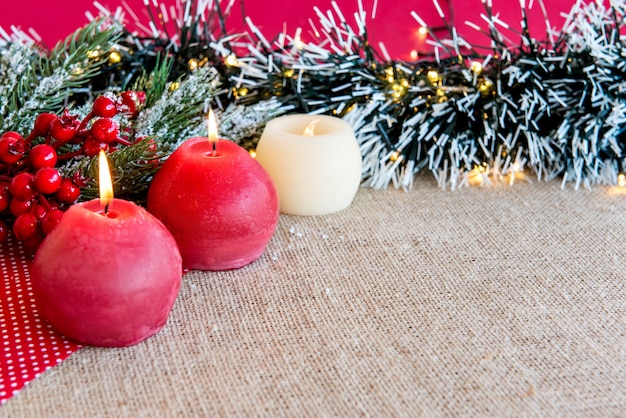 Candles on a Christmas table with Christmas ornaments.