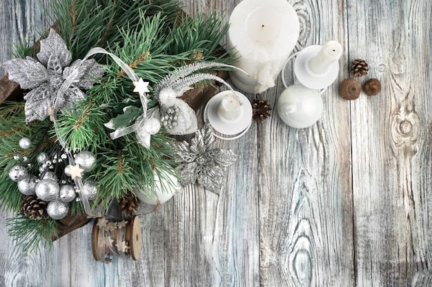 Candles and decorated pine branches on a wooden background