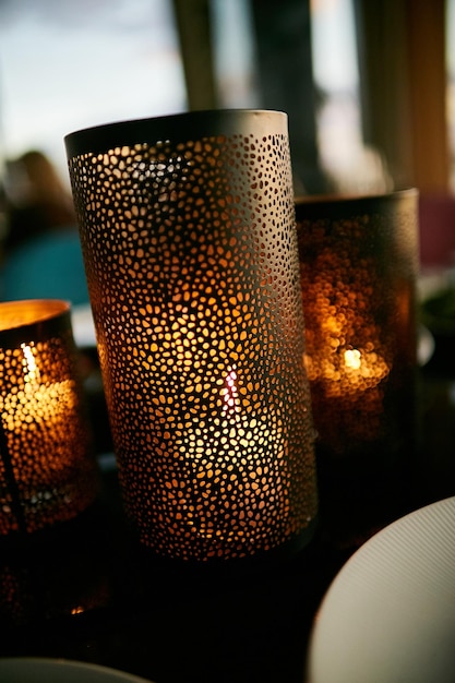 candles in decorative metal glasses on the table candles in metal cup holders