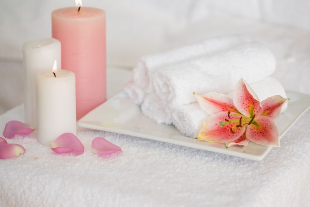 Candles and fresh white towels with lily