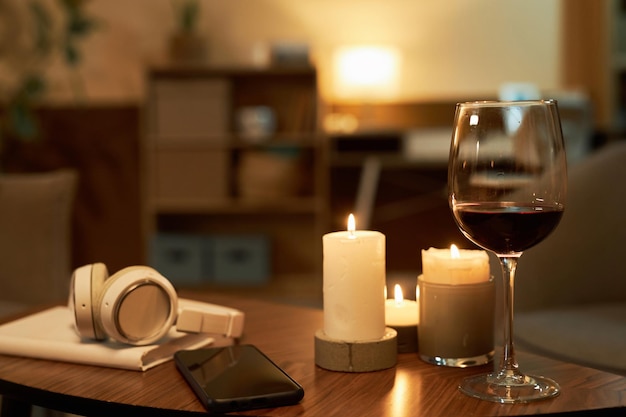 Candles and glass of wine on wooden table