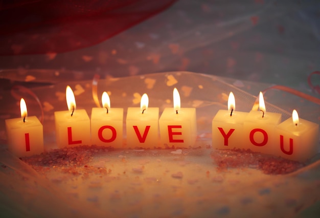 Candles with printed sign I LOVE YOU,on  color fabric background