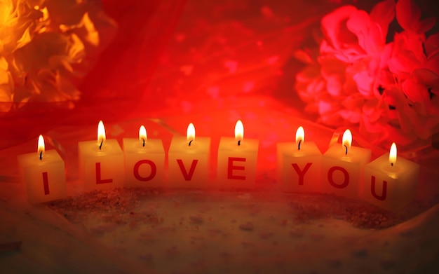 Candles with printed sign I LOVE YOU,on  color fabric background