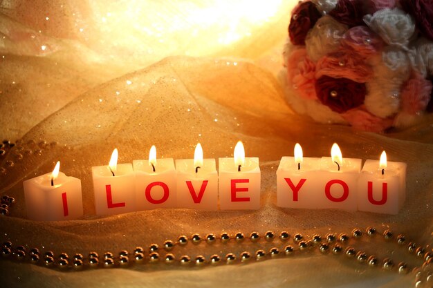 Candles with printed sign i love you,on dark background