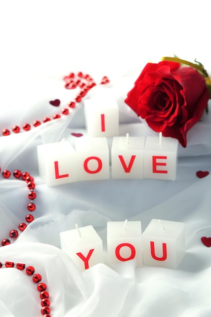 Candles with printed sign I LOVE YOU,on white fabric background