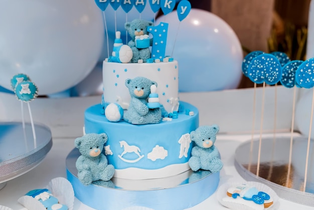 Candy bar Baby birthday theme with teddy bear Festive background decoration with cake letters saying one and white blue balloons in studio