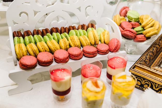 Candy bar Delicious wedding reception on dessert table Festive table with sweets candies desserts tartlet and cupcakes Side view Close up