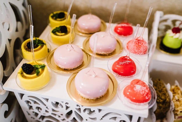 Candy bar Delicious wedding reception on dessert table Festive table with sweets candies desserts tartlet and cupcakes Side view Close up