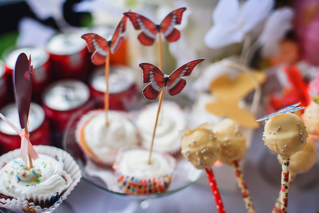 Candy bar with cupcakes and lollipops decorated with butterflies